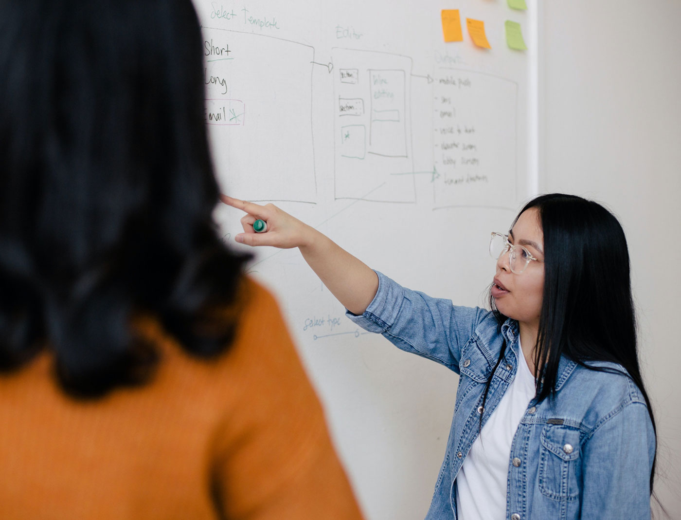 An admissions professional pointing to notes on a whiteboard