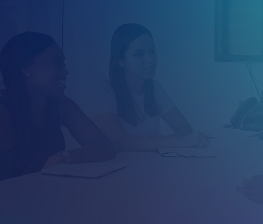 Three people talking across a table in an office