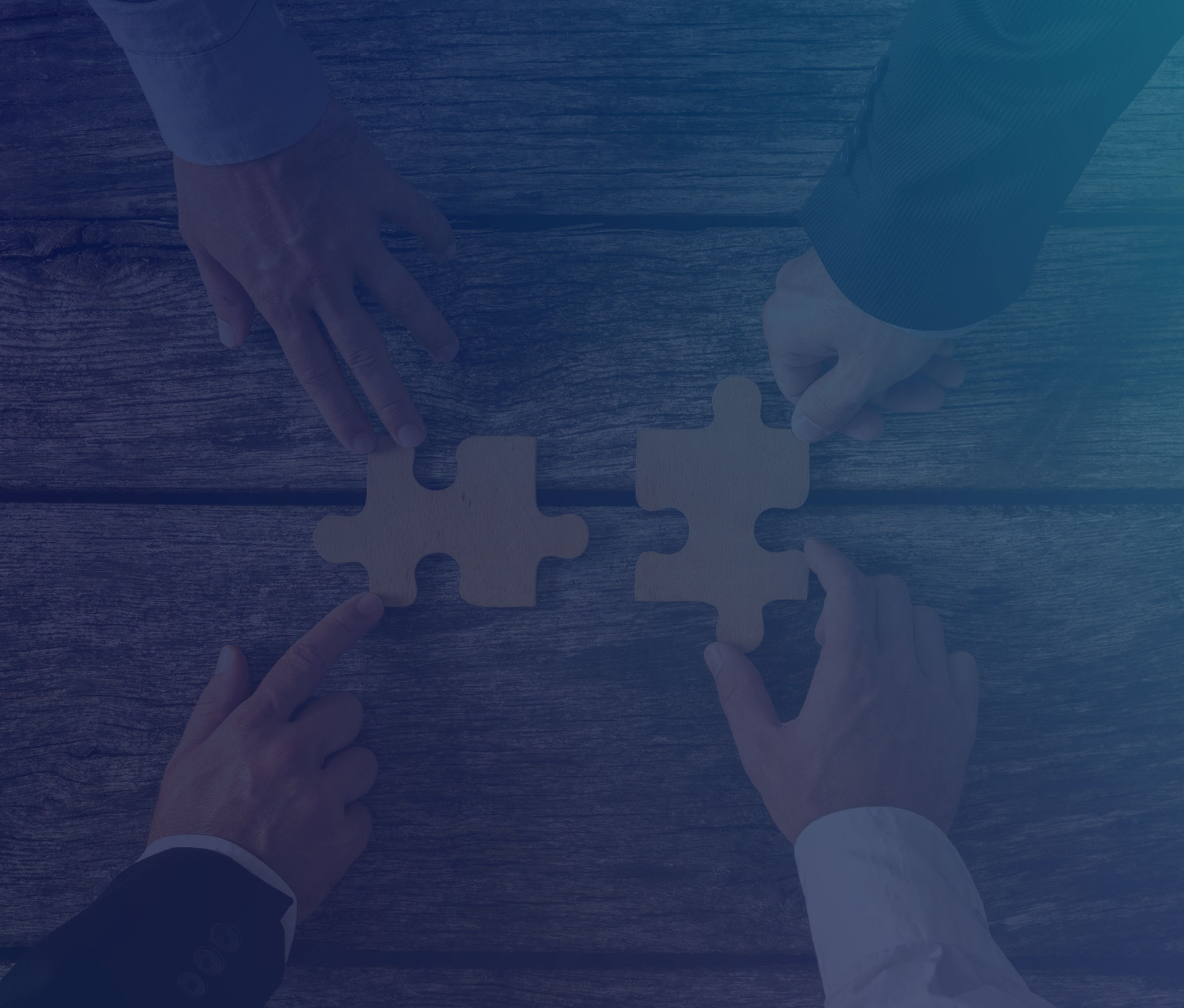 Four hands putting together two puzzle pieces